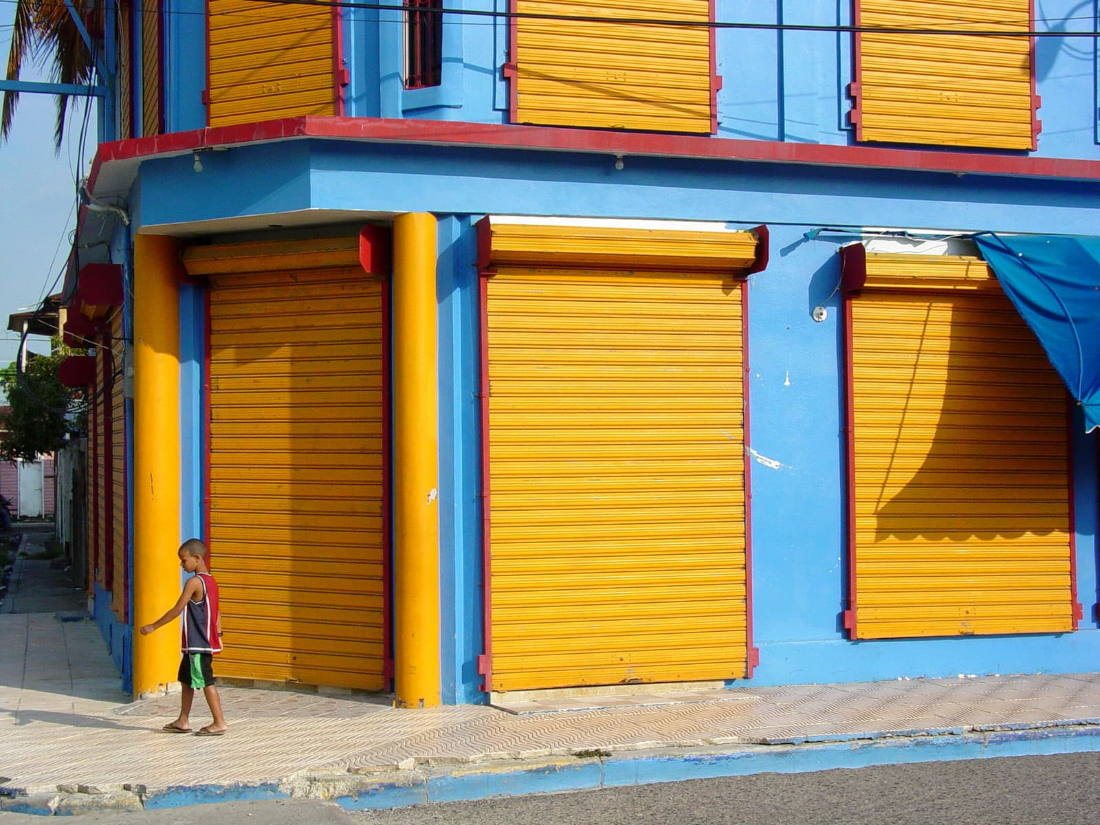A brightly painted corner building with yellow shutters in Puerto Plata