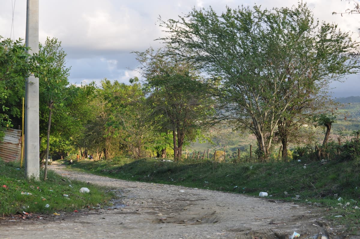 A dirt track through green Dominican countryside